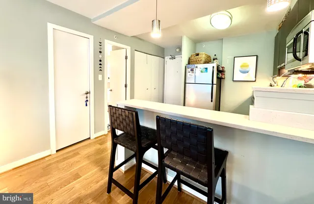 a kitchen with stainless steel appliances a dining table chairs and refrigerator