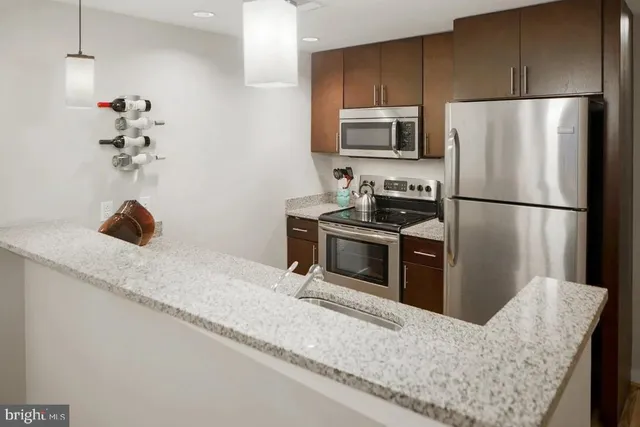 a kitchen with stainless steel appliances granite countertop a refrigerator a stove a sink and a granite counter tops