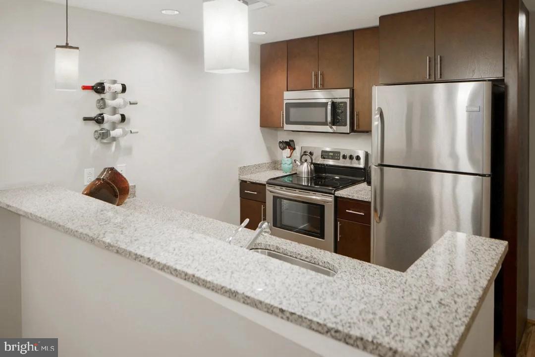 1825 Northwest 7th Street Northwest, Unit 2 BR 2 Washington, DC 20001 - Photo 3 of 9 a kitchen with stainless steel appliances granite countertop a refrigerator a stove a sink and a granite counter tops