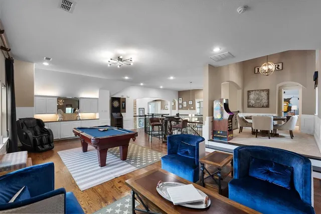 a living room with furniture a table and kitchen view