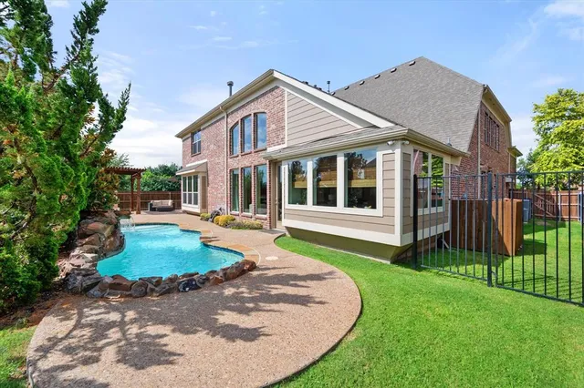 a view of a house with a yard fire pit and couches in the patio
