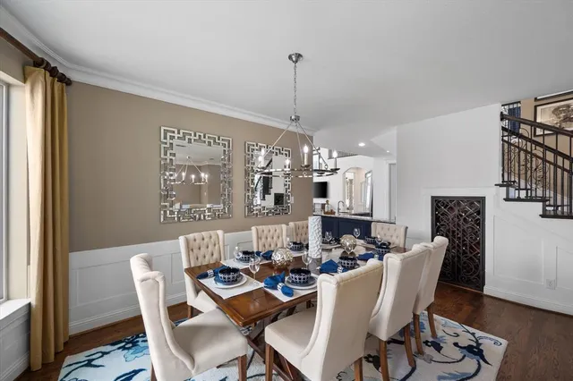 a dining room with furniture a chandelier and wooden floor