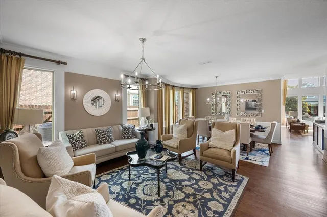 a living room with furniture wooden floor and a large window