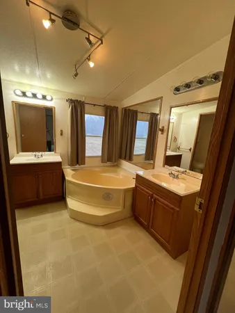 a spacious bathroom with a tub double vanity and a shower