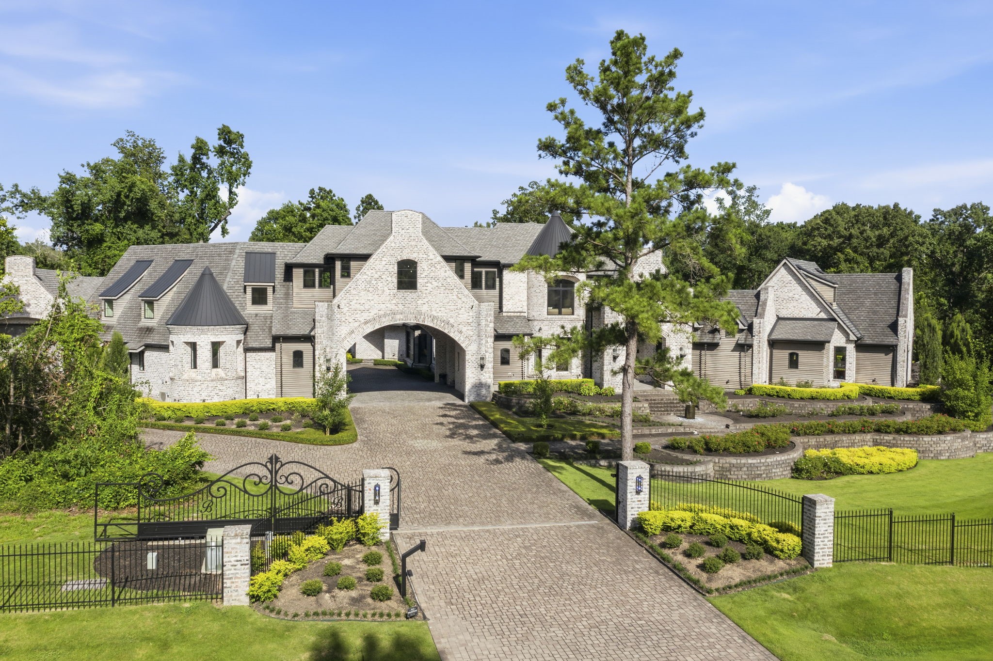 27006 Star Gazer Way Spring, TX 77386 - Photo 1 of 50 WELCOME HOME! Timeless luxury begins at the entrance with a private gated drive, custom wrought iron fencing, premium Pella windows, iron doors, cypress siding, and beautiful brick architecture.