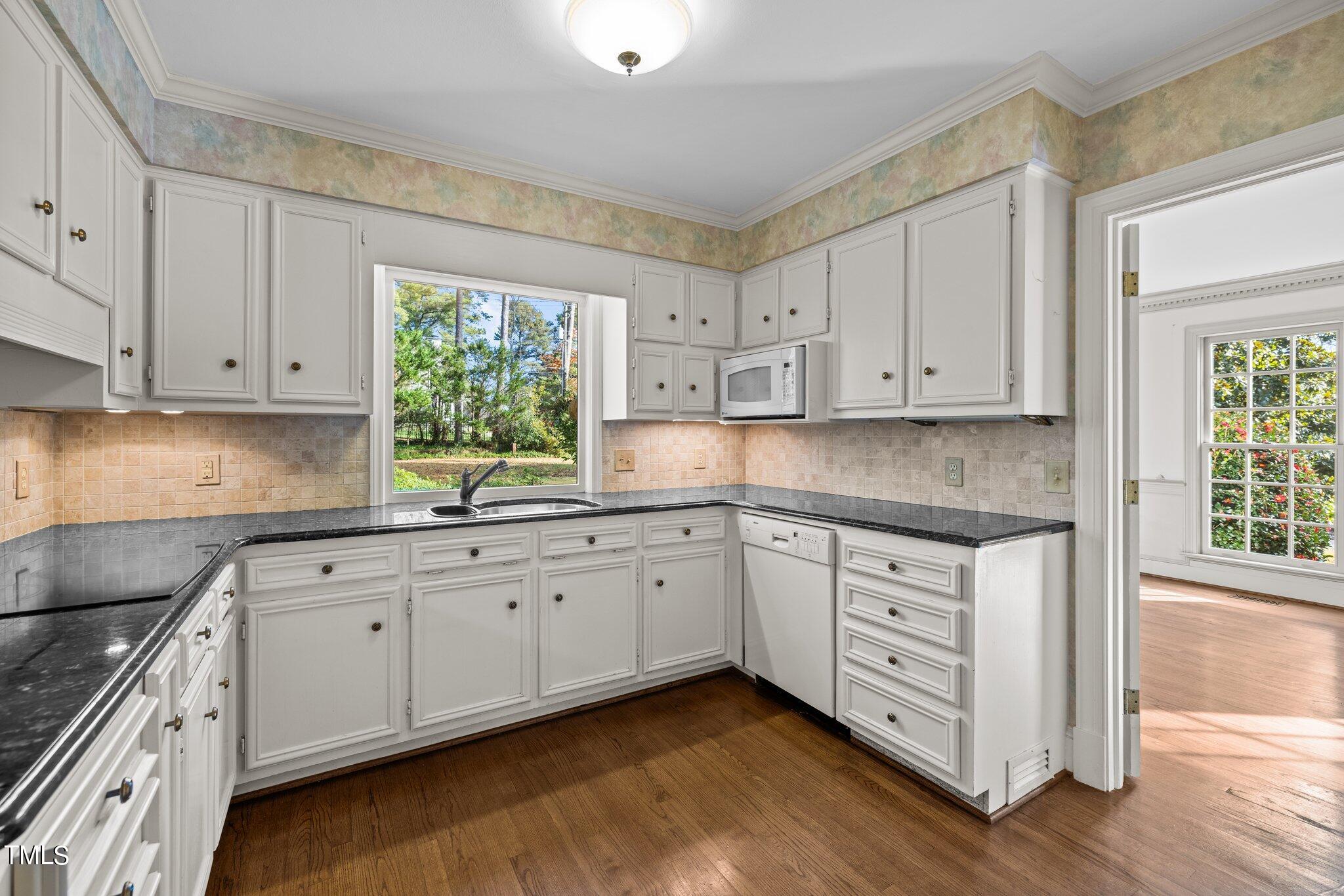 3608 Dover Road Durham, NC 27707 - Photo 34 of 58 a kitchen with granite countertop white cabinets white appliances a sink and dishwasher with wooden floor