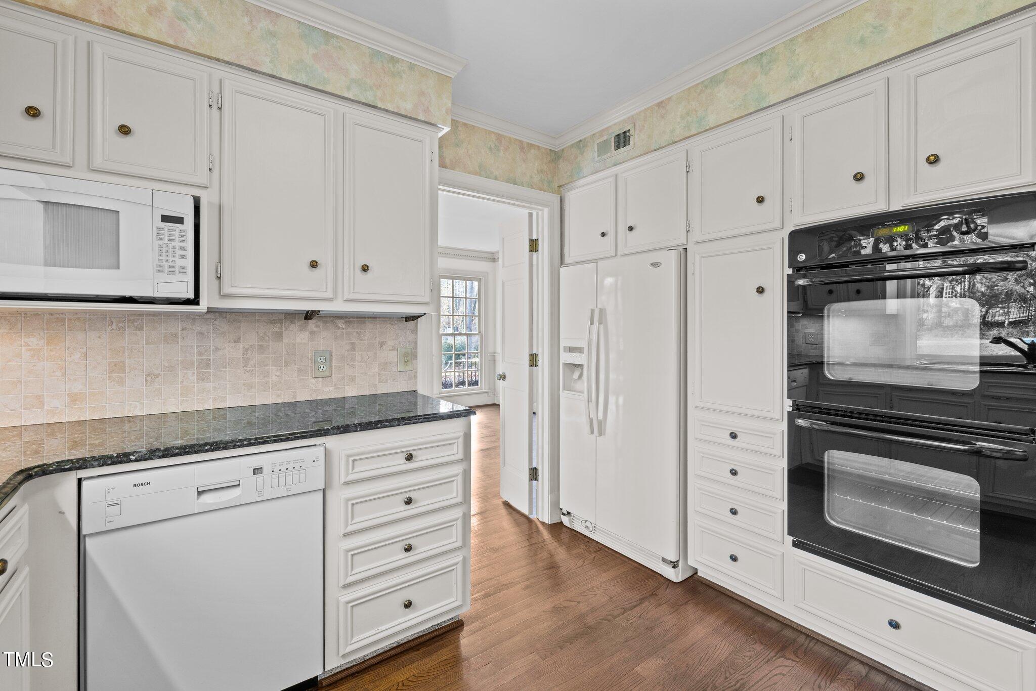 3608 Dover Road Durham, NC 27707 - Photo 35 of 58 a kitchen with granite countertop white cabinets and stainless steel appliances