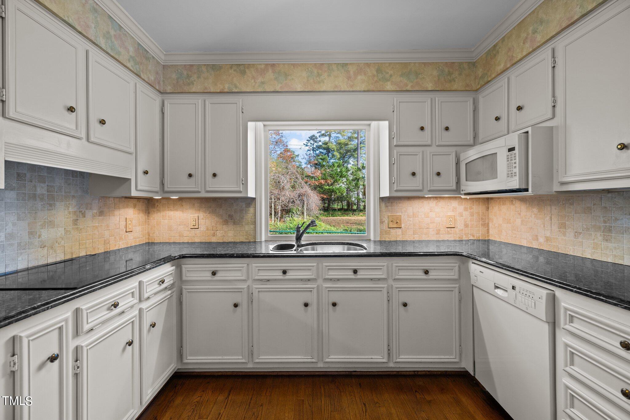 3608 Dover Road Durham, NC 27707 - Photo 36 of 58 a kitchen with white cabinets white appliances and a sink
