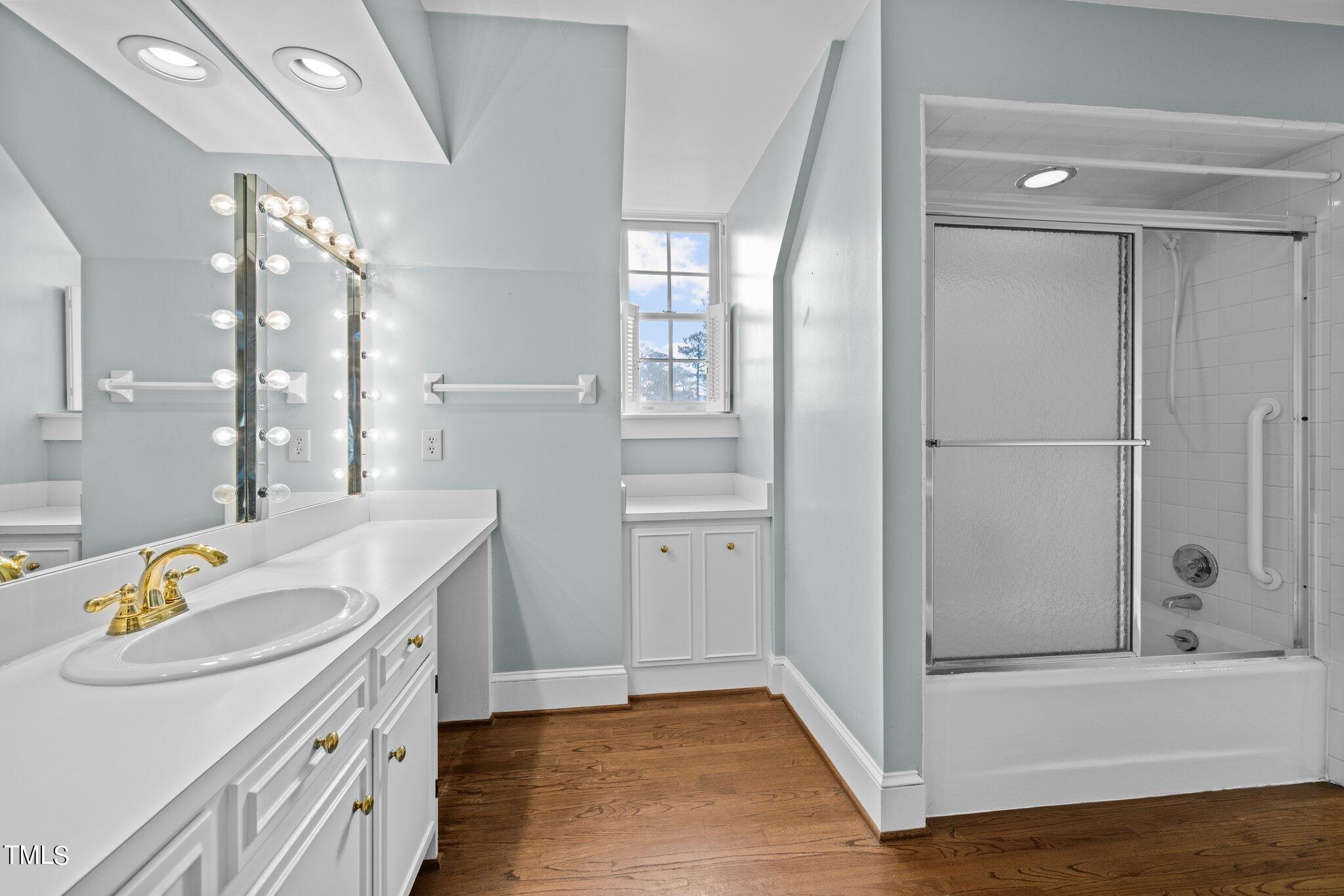 3608 Dover Road Durham, NC 27707 - Photo 38 of 58 a bathroom with a tub a sink and a mirror