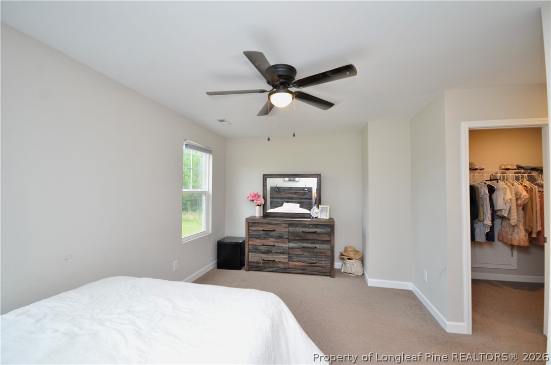 1865 John B Carter Road Fayetteville, NC 28312 - Photo 33 of 49 a bedroom with a bed and a chandelier