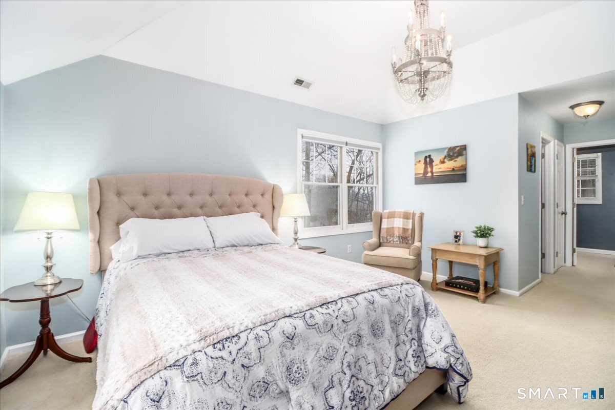 52 Key Rock Road Newtown, CT 06470 - Photo 21 of 40 a bedroom with a bed and a chandelier