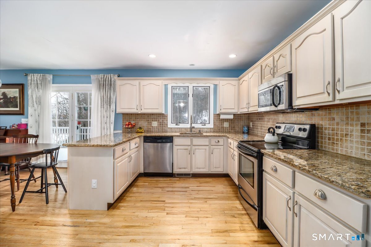 52 Key Rock Road Newtown, CT 06470 - Photo 4 of 40 a kitchen with stainless steel appliances granite countertop a stove top oven a sink dishwasher and cabinets with wooden floor