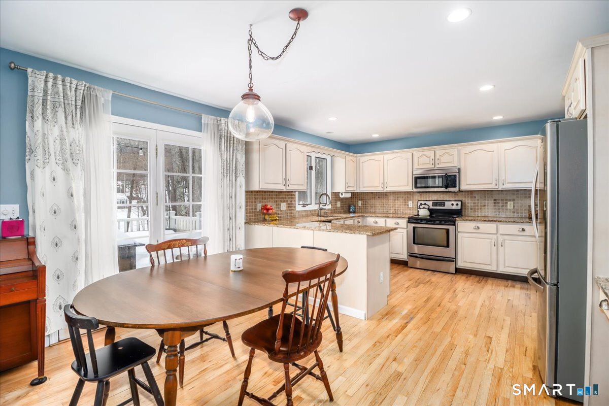 52 Key Rock Road Newtown, CT 06470 - Photo 6 of 40 a kitchen with a table chairs refrigerator and cabinets