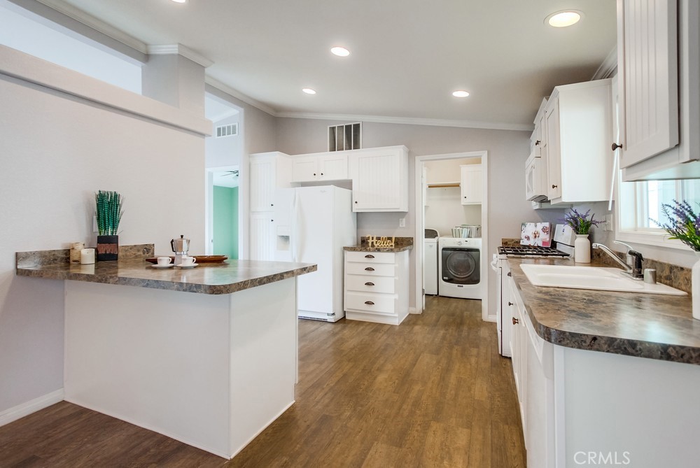 3909 Reche Road, Unit 185 Fallbrook, CA 92028 - Photo 17 of 22 a kitchen with white cabinets and stainless steel appliances
