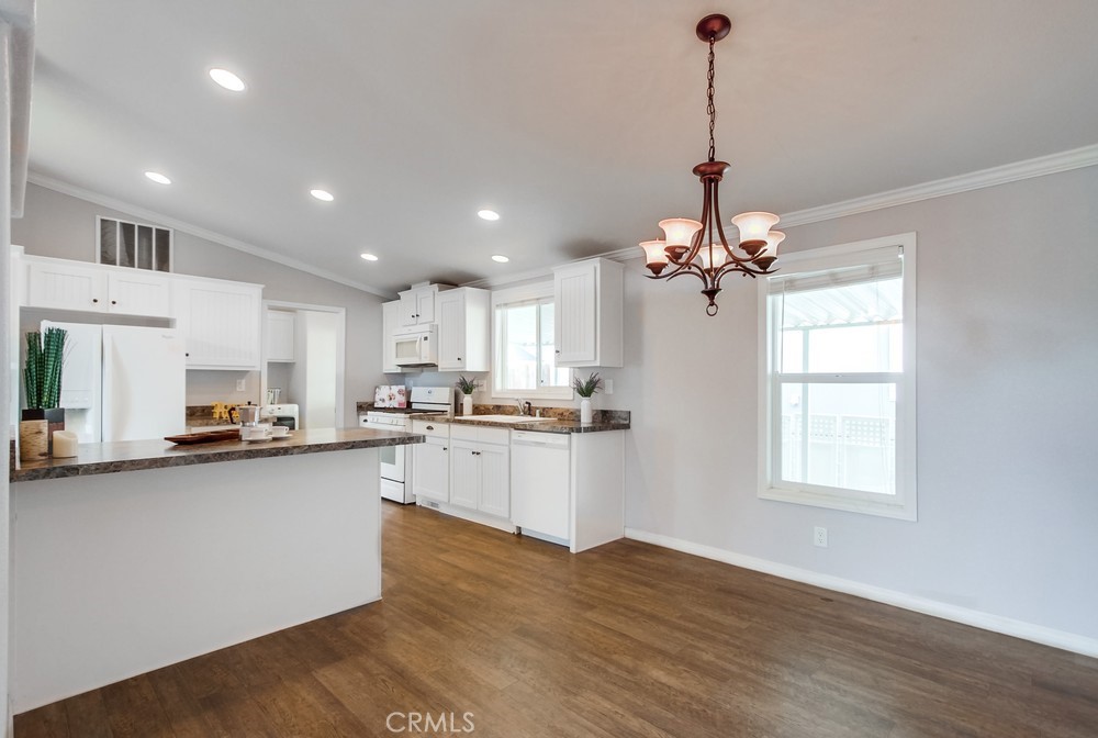 3909 Reche Road, Unit 185 Fallbrook, CA 92028 - Photo 18 of 22 a kitchen with kitchen island granite countertop a sink cabinets and wooden floor