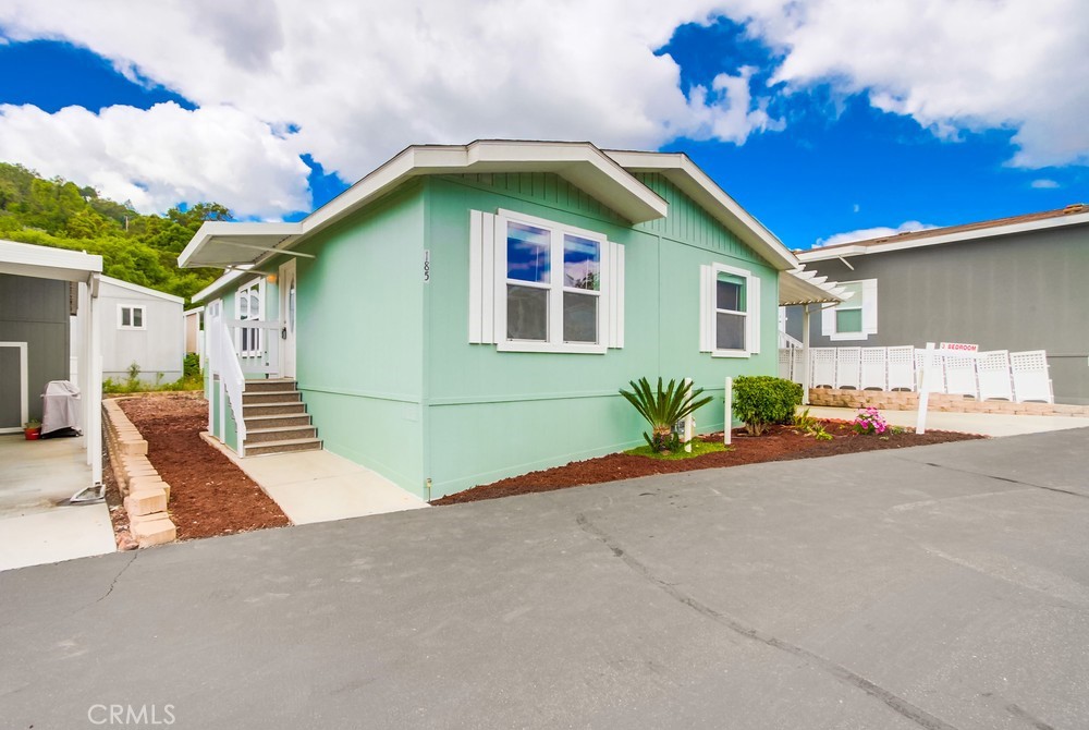 3909 Reche Road, Unit 185 Fallbrook, CA 92028 - Photo 22 of 22 a front view of a house with a yard and potted plants