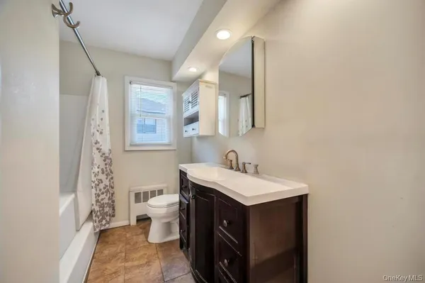 a bathroom with a sink toilet vanity and mirror