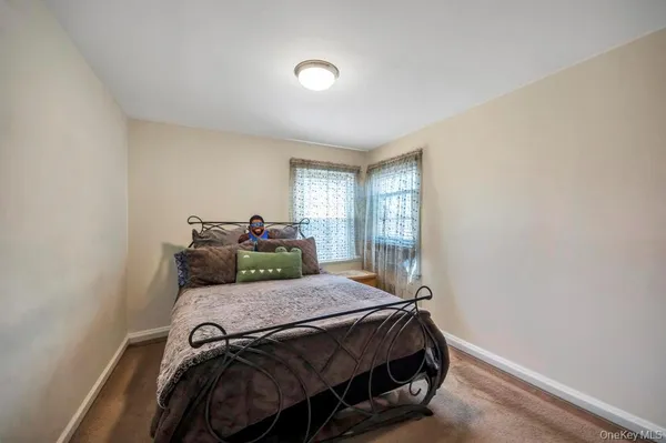 a bed sitting in a bedroom next to a window
