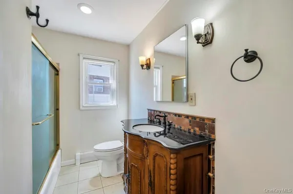 a bathroom with a granite countertop sink a toilet and a mirror