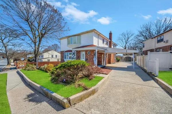 a front view of a house with a yard and potted plants
