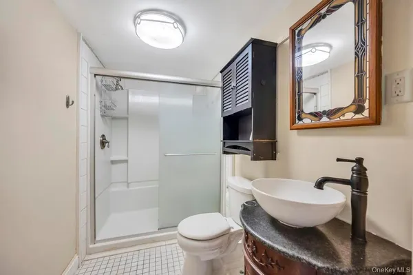 a bathroom with a toilet sink a mirror and shower