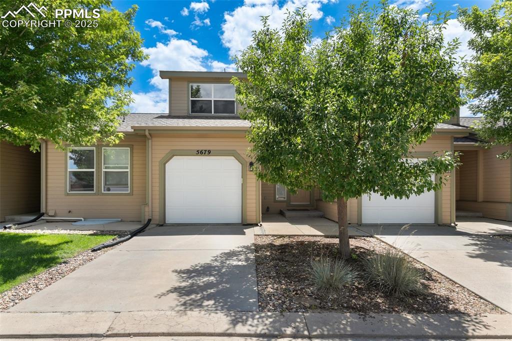 5679 Sunshade Point Colorado Springs, CO 80923 - Photo 2 of 30 a front view of a house with a yard and a garage