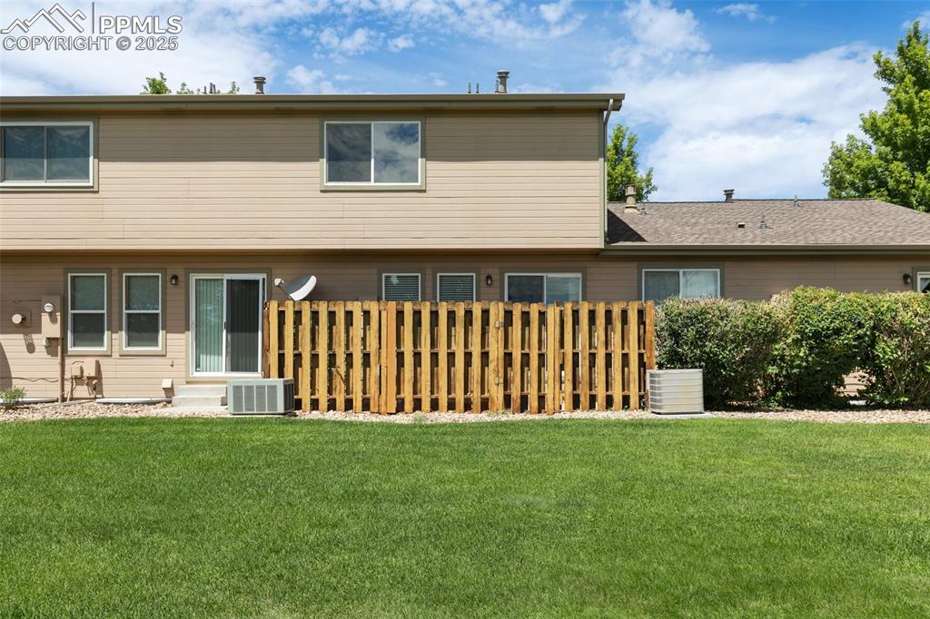 5679 Sunshade Point Colorado Springs, CO 80923 - Photo 26 of 30 a front view of a house with a garden and yard