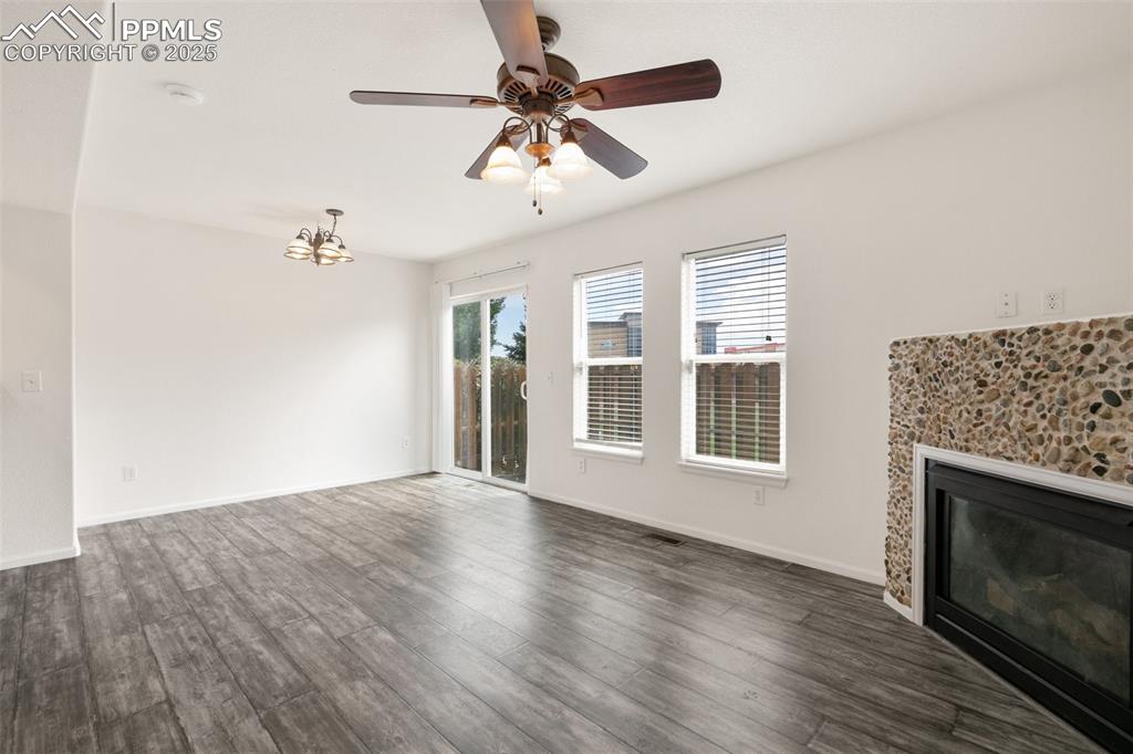 5679 Sunshade Point Colorado Springs, CO 80923 - Photo 4 of 30 a view of an empty room with a fireplace and a window