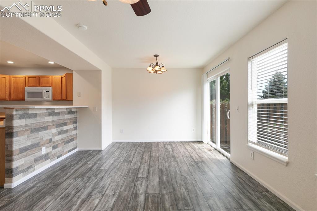 5679 Sunshade Point Colorado Springs, CO 80923 - Photo 6 of 30 wooden floor in an empty room with a window
