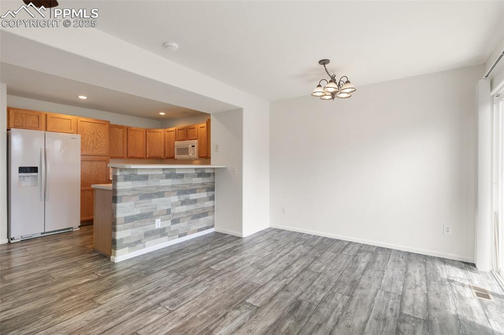 5679 Sunshade Point Colorado Springs, CO 80923 - Photo 7 of 30 wooden floor in an empty room with a window