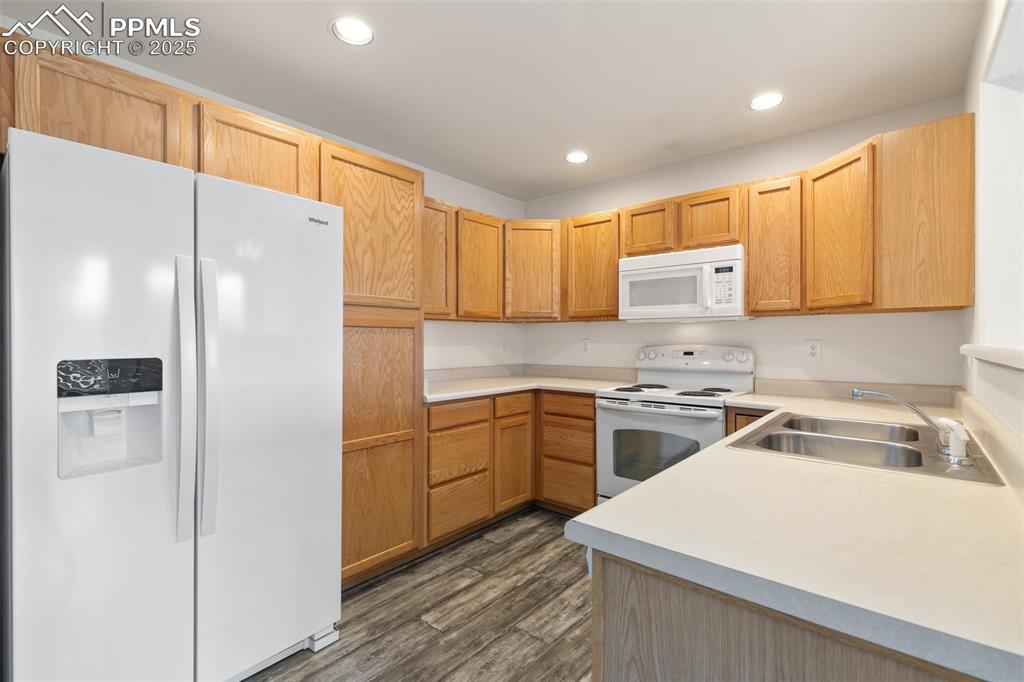 5679 Sunshade Point Colorado Springs, CO 80923 - Photo 8 of 30 a kitchen with a refrigerator a sink and cabinets