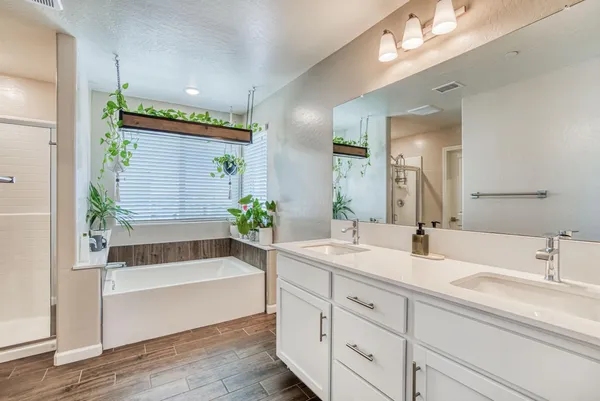 a bathroom with a tub a sink and mirror