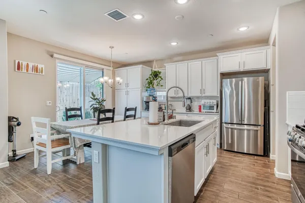 a kitchen with a sink stools a counter space and stainless steel appliances