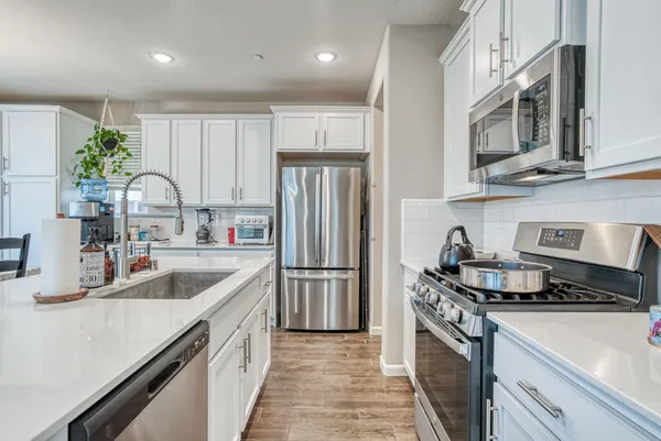 a kitchen with stainless steel appliances granite countertop a sink stove and refrigerator