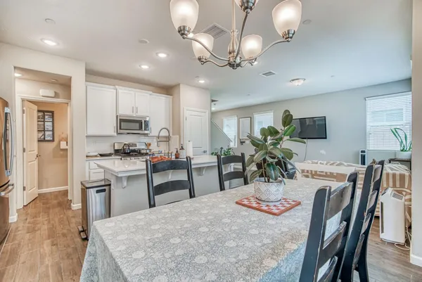 a kitchen with stainless steel appliances kitchen island granite countertop a stove a refrigerator a kitchen island a dining table and chairs