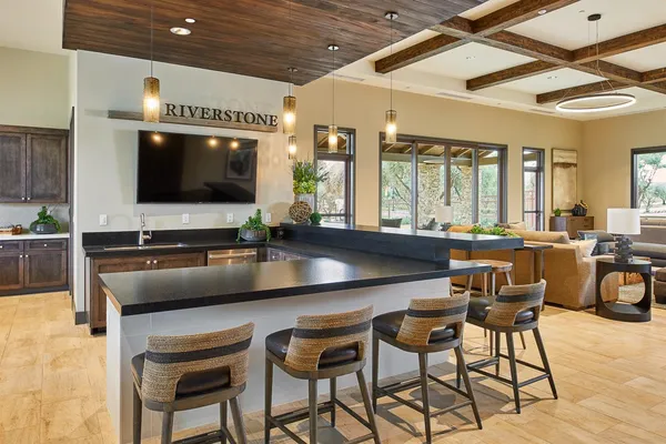 a kitchen with granite countertop a table chairs stove and flat screen tv