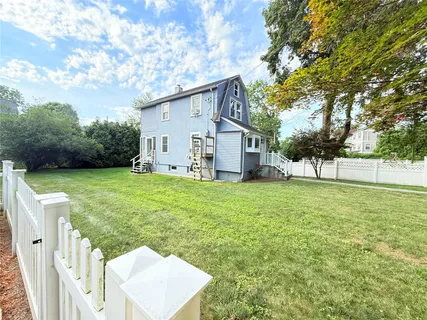a view of a house with backyard and a tree
