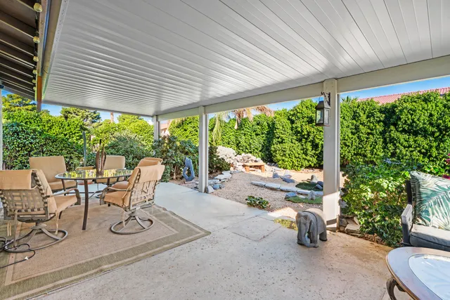 a view of a patio with table and chairs under an umbrella