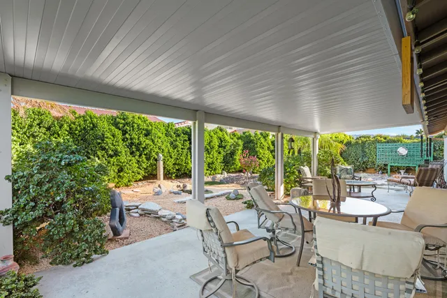 a patio with yard glass top table and chairs