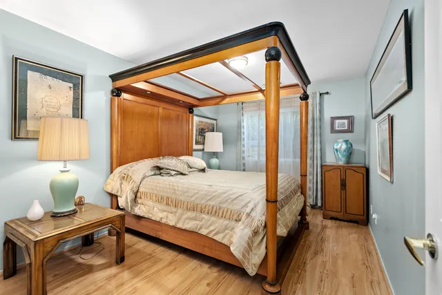 a bedroom with a bed and wooden floor