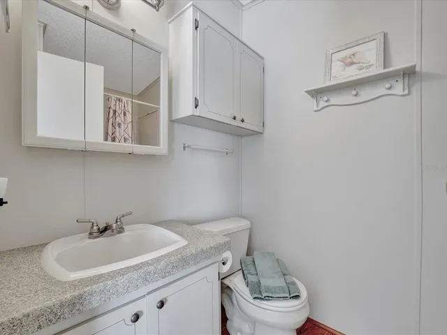 a bathroom with a sink a toilet and a mirror