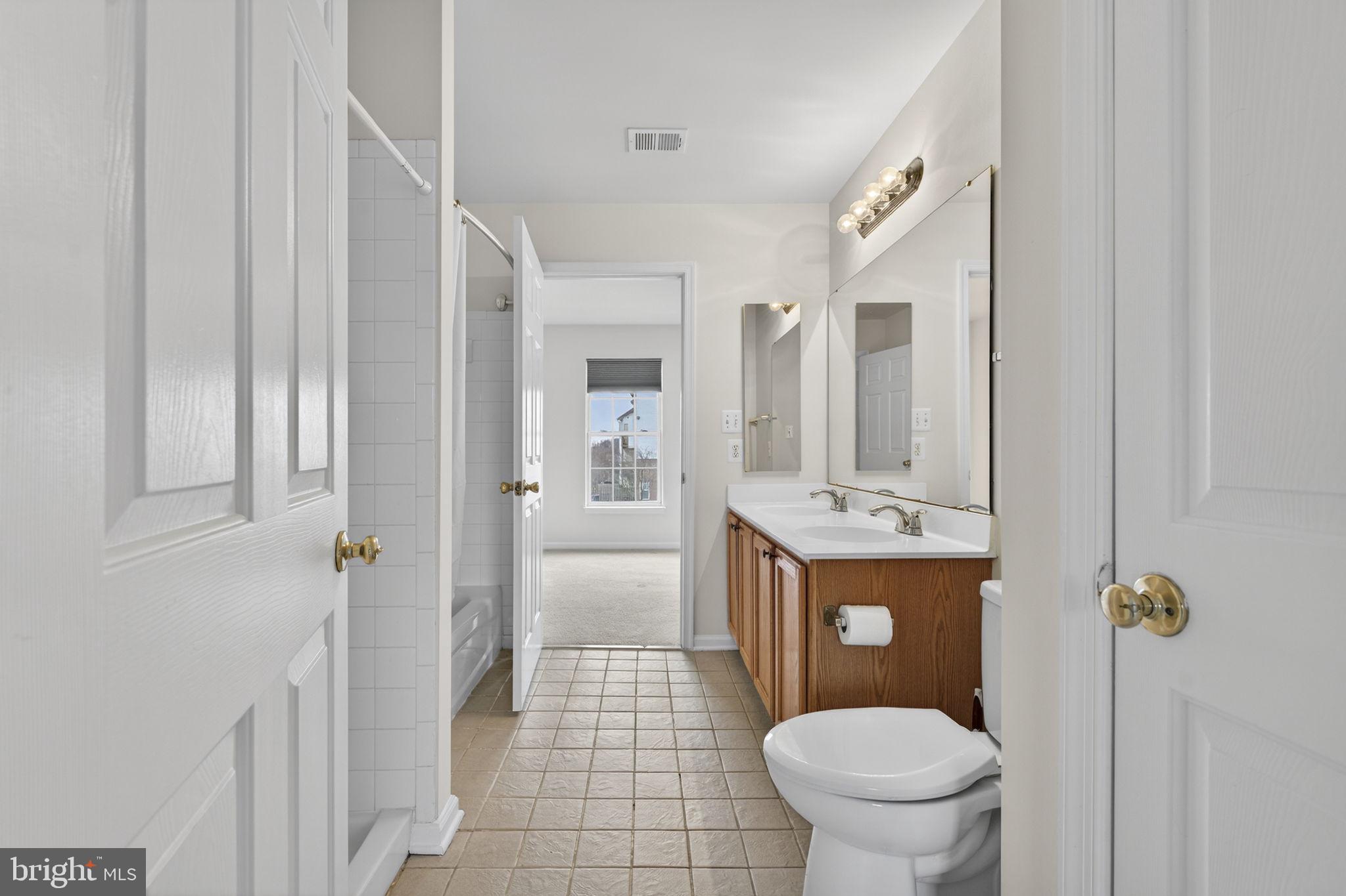 6741 Stone Maple Terrace Centreville, VA 20121 - Photo 19 of 24 a bathroom with a granite countertop toilet a sink and a mirror