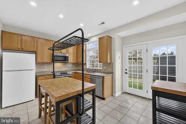 a kitchen with a table chairs refrigerator and cabinets