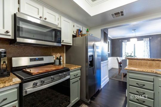 420 Montefino Drive Ridgecrest, CA 93555 - Photo 15 of 38 a kitchen with stainless steel appliances granite countertop a stove a microwave and a refrigerator