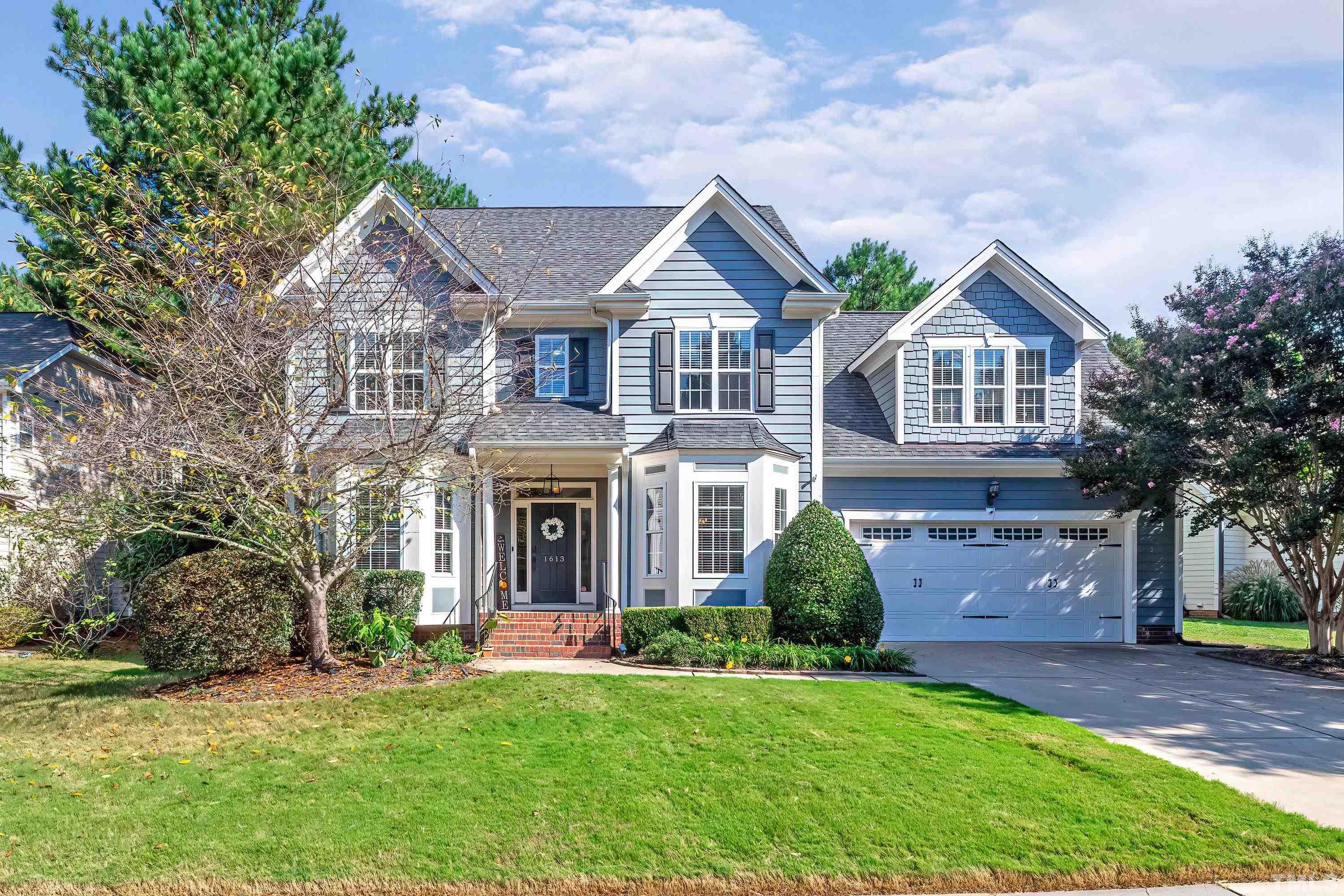 a front view of a house with a garden and plants