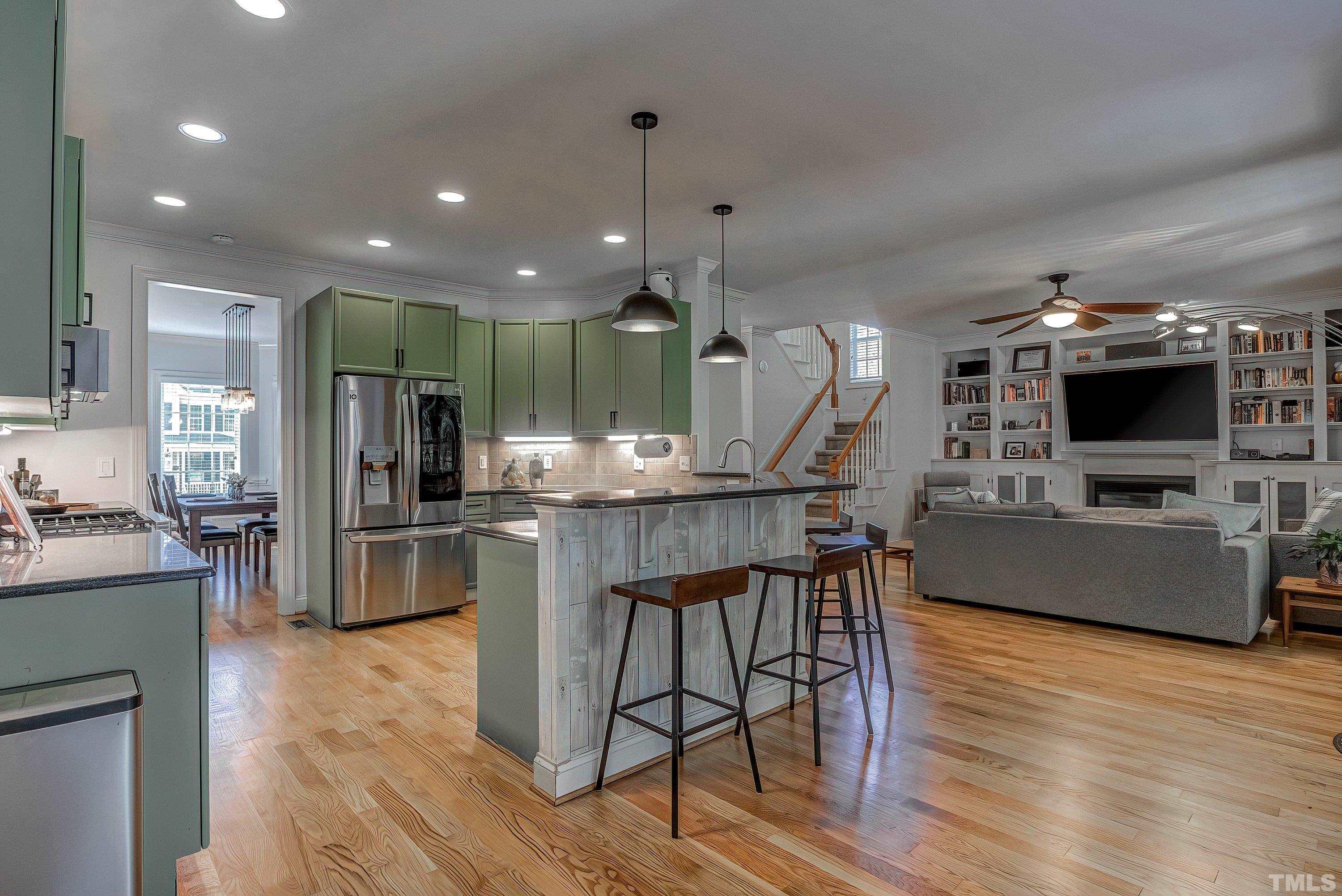 1613 Strategy Way Wake Forest, NC 27587 - Photo 21 of 58 a kitchen with stainless steel appliances kitchen island granite countertop a stove top oven a sink a dining table and chairs