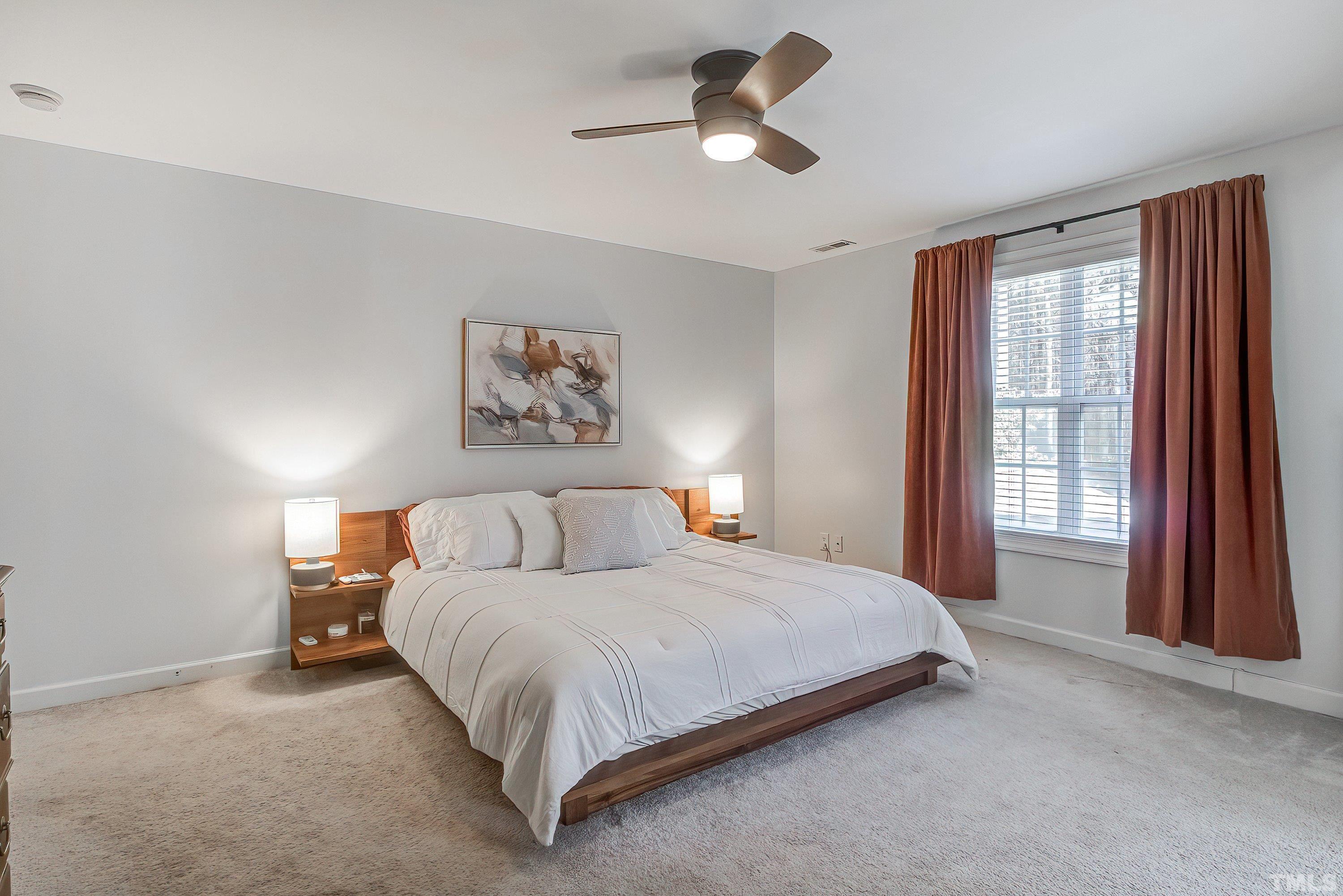 1613 Strategy Way Wake Forest, NC 27587 - Photo 27 of 58 a bedroom with a large bed and a large window