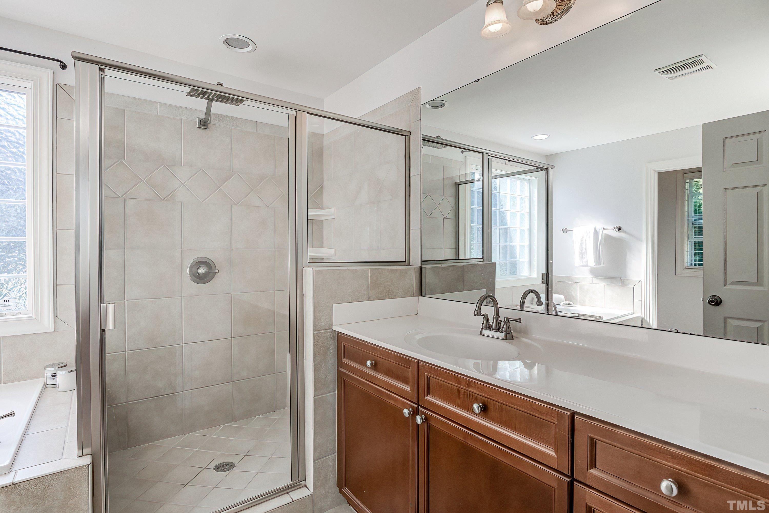 1613 Strategy Way Wake Forest, NC 27587 - Photo 31 of 58 a bathroom with a shower sink and mirror
