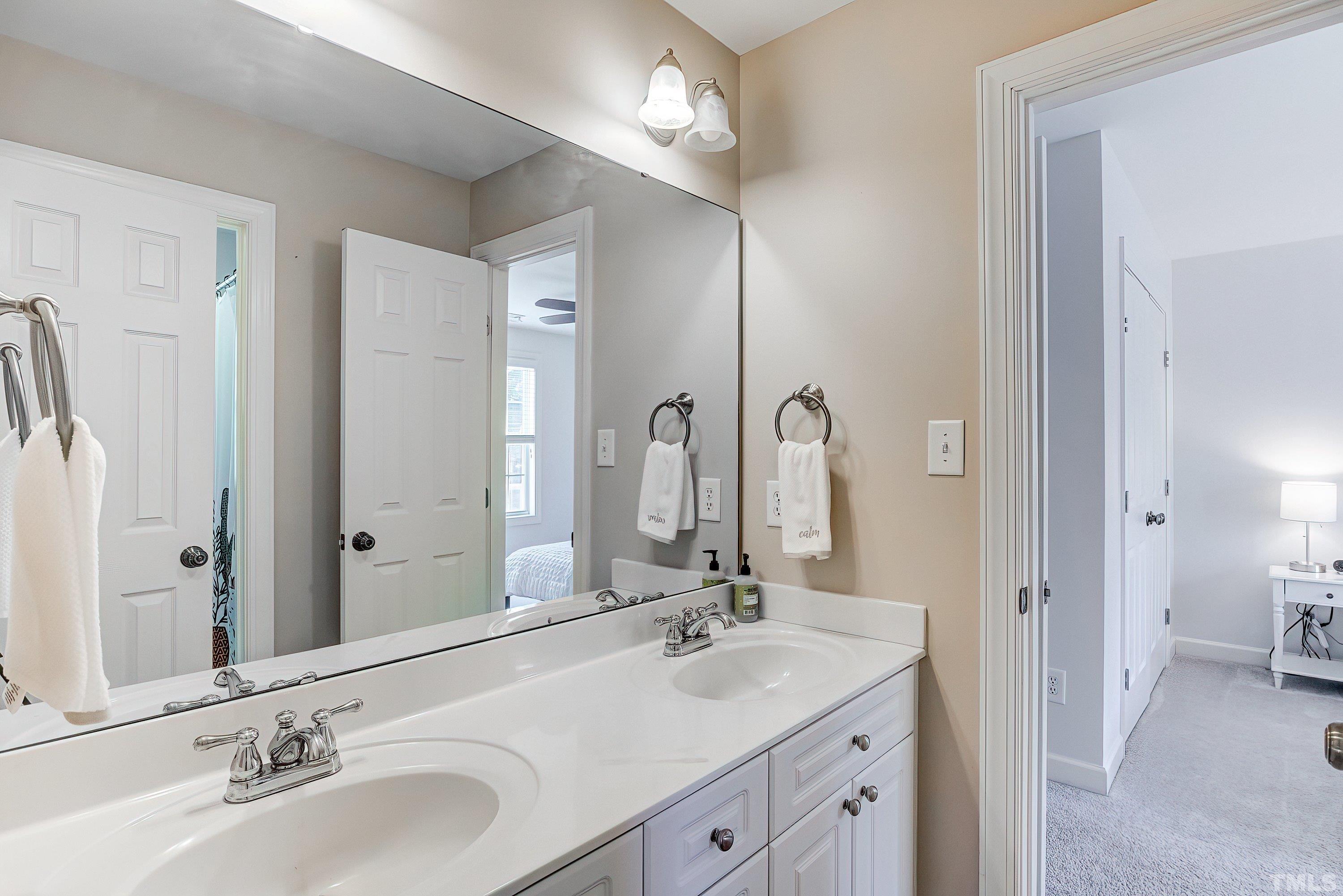 1613 Strategy Way Wake Forest, NC 27587 - Photo 37 of 58 a bathroom with double vanity sinks and a mirror