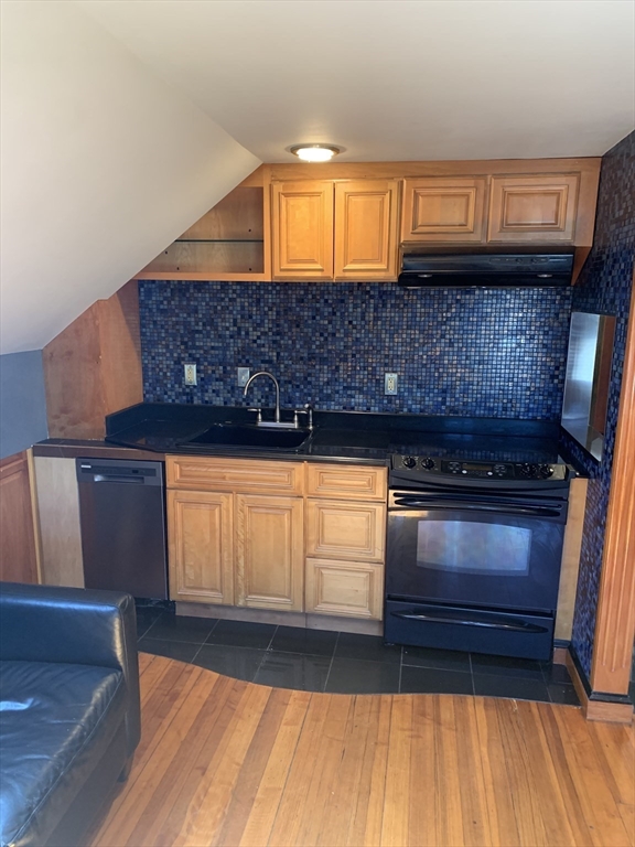 a kitchen with granite countertop a stove and a wooden cabinets